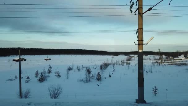 鉄道近くの冬の村と一緒に動き 電車の窓から見ると — ストック動画