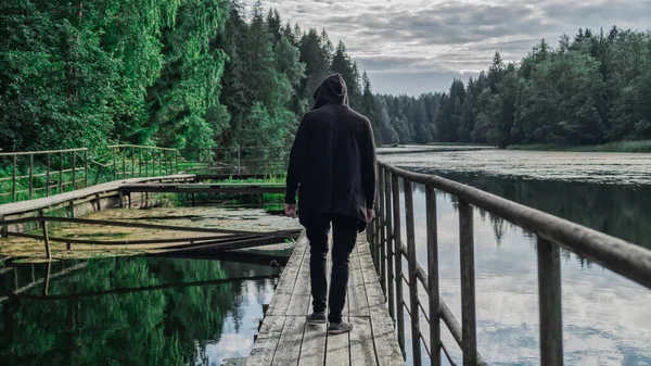 Man Met Kap Loopt Langs Pier Achteraanzicht — Stockfoto