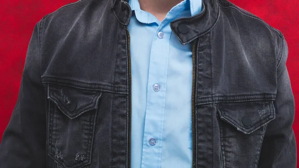 Jeans jacket and blue shirt worn by a man close up