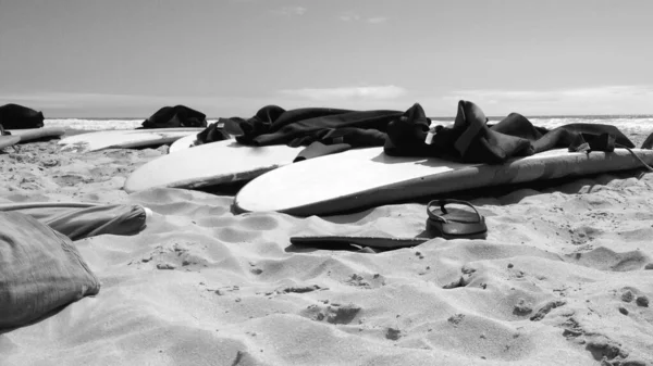 Surfboards Wetsuits Lie Beach Slippers Sand — Φωτογραφία Αρχείου
