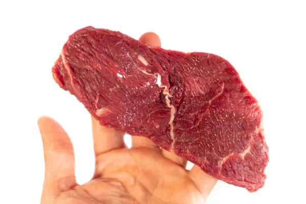 Der Mann hält ein rohes Steak in der Hand. Frisches rohes Rindersteak isoliert auf weißem Hintergrund. — Stockfoto
