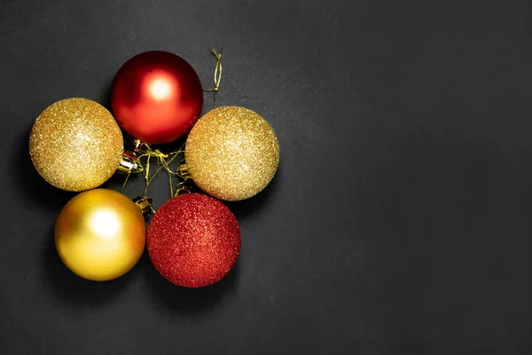 Decoraciones rojas y doradas de Navidad sobre un fondo oscuro. Piso tendido, vista superior. — Foto de Stock