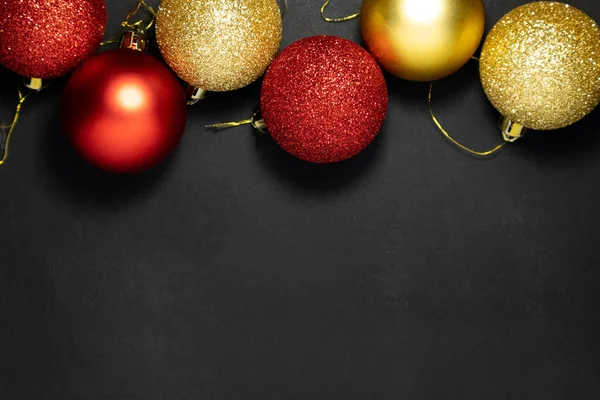 Koyu bir arka planda Noel kırmızısı ve altın süslemeler. Düz yatış, üst görünüm. — Stok fotoğraf