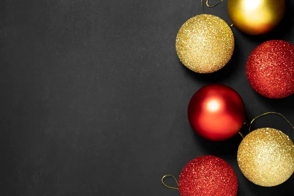 Decoraciones rojas y doradas de Navidad sobre un fondo oscuro. Piso tendido, vista superior. — Foto de Stock