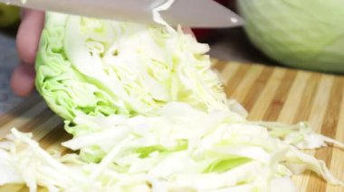 Tahta kesme tahtasında beyaz lahana dilimlenmiş..