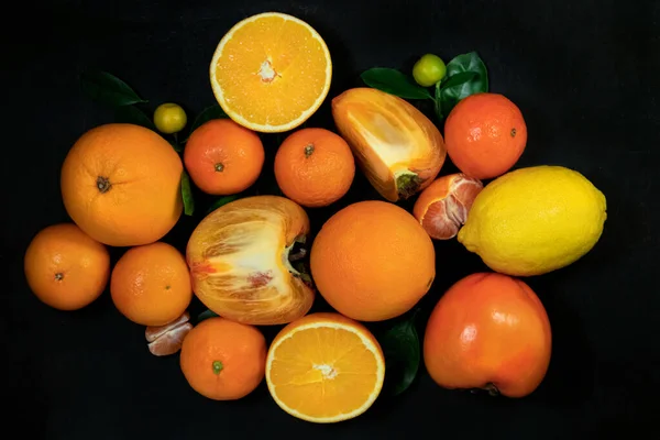 Orange fruits with leaves on a black background. Top view. — Stock Photo, Image