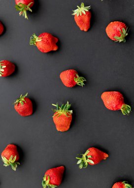 Siyah arka planda olgun çilekler, yaz meyveleri, üst manzara.