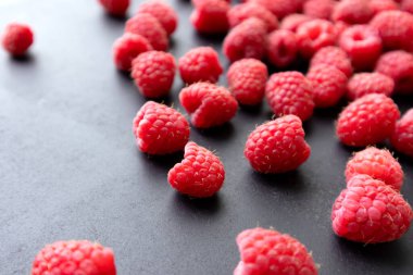 Taze ve tatlı ahududu, koyu bir arka planda. Seçici odak.