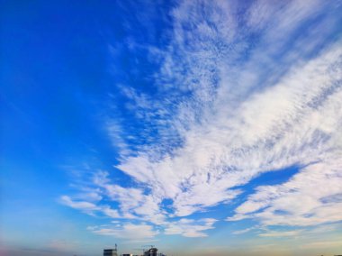 Pofuduk beyaz bulutlu parlak mavi gökyüzü. Güneş ışığıyla aydınlatılan yumuşak bulut şekilli doğal bir arka plan. Hava, doğa ve manzara temaları için mükemmel