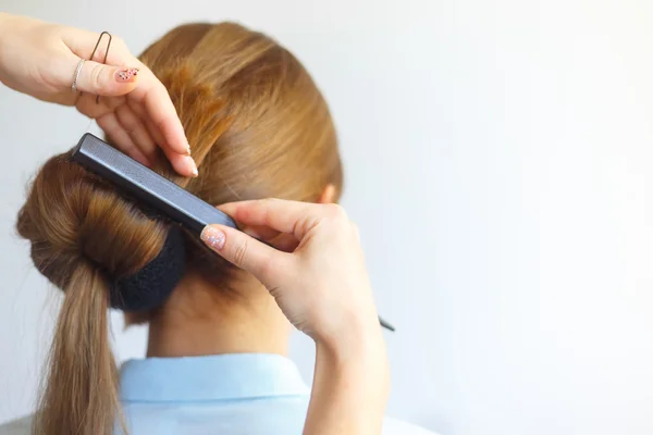 Профессиональная женщина парикмахер делает прическу веселой молодой женщине с длинными волосами — стоковое фото
