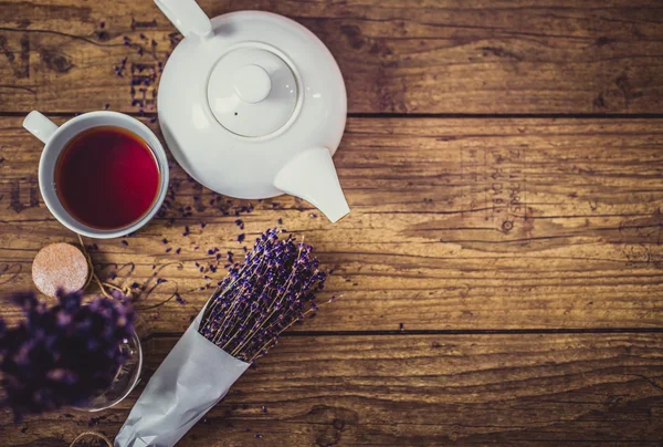 Bir avuç kuru kesim lavanta, fincan çay ve çaydanlık ahşap masa üzerinde. Üstten Görünüm. İle spase ürün veya işareti metin için.