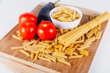 Ham İtalyan makarna domates ve diğer sebzeler, üstten görünüm arka plan ile farklı türleri. Seçilen odak.