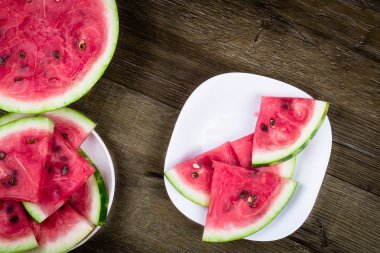 Karpuz dilimleri şeklinde üçgen plaka karanlık grungy zemin üzerine yerleştirilir. Üstten Görünüm.