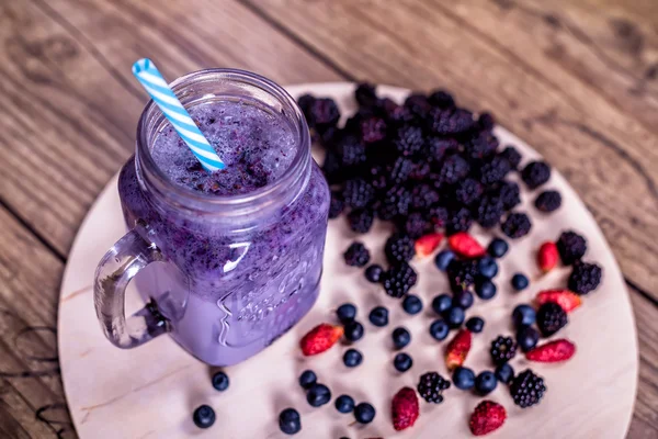 Fresh homemade yogurt smoothie wild berries in a glass jar on an old vintage background, closeup, top view, selective focus. Harvest Concept. — Stock Photo, Image