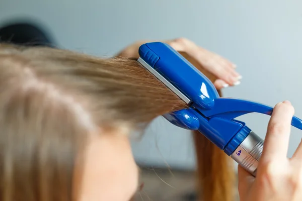 Friseurfrisurenmodelle mit dem Glätteisen. Nahaufnahme. Selektiver Fokus. — Stockfoto