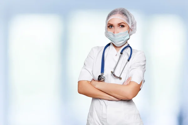 Medical surgeon doctor woman over blue clinic background. With place for medical advertise. Medical advertising concept. — Stock Photo, Image