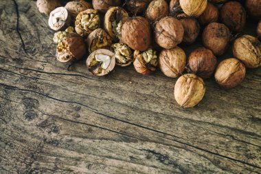 Taze ceviz eski ahşap masa, sağlıklı beslenme cocept, seçici odak sonbahar arka plan üzerinde bir hasır sepet dışarı dökmek. Üstten Görünüm.