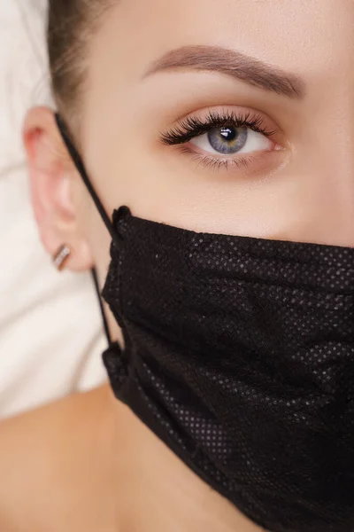 Ögonfransförlängningsprocedur. Vacker kvinna med extremt långa falska ögonfransar. Makeup, kosmetika. Skönhet, Skincare. Kvinna i medicinsk mask. — Stockfoto