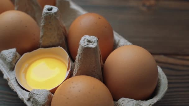 Oeufs frais de poulet brun dans une boîte en carton sur la table. Photo de diapositive. — Video