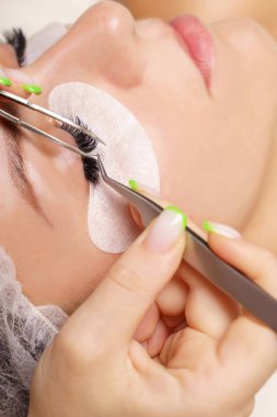 Kirpik uzatma prosedürü. Uzun kirpikli kadın gözü. Yaklaş, seçici odaklanma.