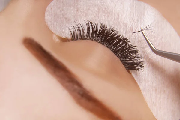 Verlengingsprocedure voor wimpers. Vrouw oog met lange wimpers. Close-up, selectieve focus. — Stockfoto