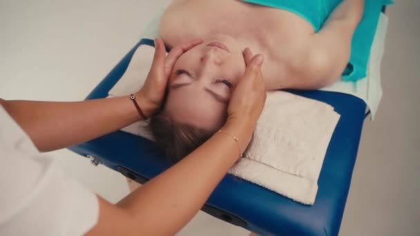 Spa kvinna ansiktsmassage. Ansiktsmassage i skönhetssalong. Kvinnliga njuter av avslappnande ansiktsmassage i kosmetologi spa centrum. Wellness, healing och avslappning koncept. — Stockvideo