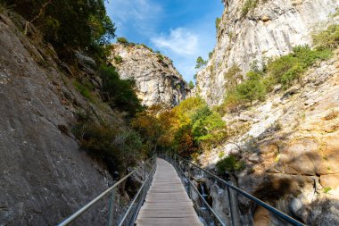 Dik Kanyon Vadisi 'nden Mavi Gökyüzüne doğru uzanan Çelik parmaklıklarla yükseltilmiş Tahta Geçit