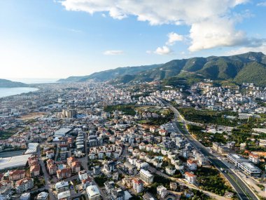 Çağdaş bir otoban köprüsünün, yemyeşil bir vadiyi geçişi ve yerleşim alanlarını kente bağlayışı yüksek açılı hava görüntüsü