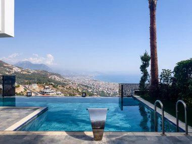 Güneşli bir günde Akdeniz Sahil Kenti ve Dağ Vista 'sına Bakan Sonsuzluk Havuzu