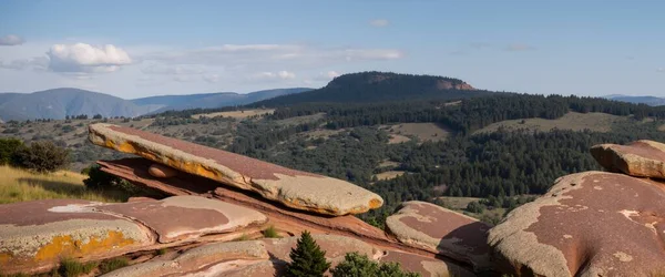 Dağları ve mavi gökyüzü olan güzel bir manzara.