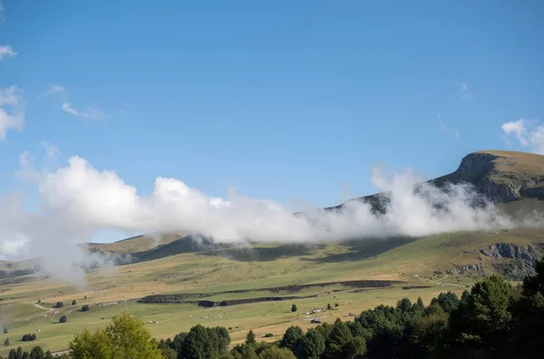 Bulutları ve mavi gökyüzü olan güzel bir manzara.