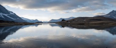Göl ve dağlarla dolu güzel bir manzara.