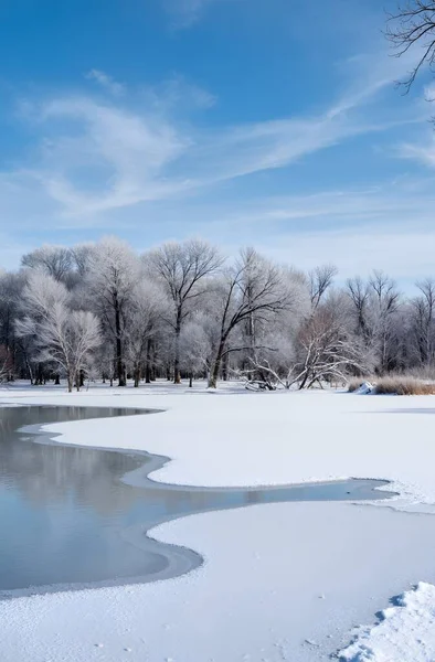 frozen river covered with ice and snow in a winter park