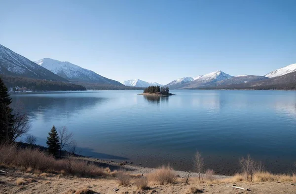 a beautiful landscape of lake and mountains with a cloudy sky