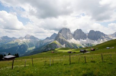 scenic view of mountains and green grass on a sunny day