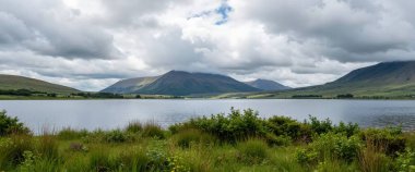 lake with a view of the mountains and clouds