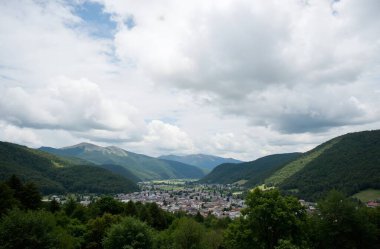 a beautiful shot of the mountains with a green valley under blue sky
