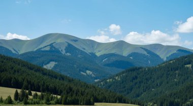 Dağları ve mavi gökyüzü olan güzel bir manzara.
