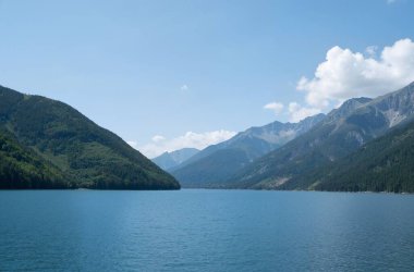 Dağları ve mavi gökyüzü olan güzel bir manzara.