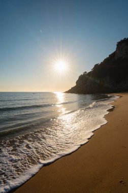 beautiful sunrise on the beach with sea, sun and clouds in the background