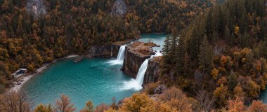 autumn waterfall with a forest in the background