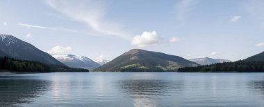 Göl ve dağlarla dolu güzel bir manzara.