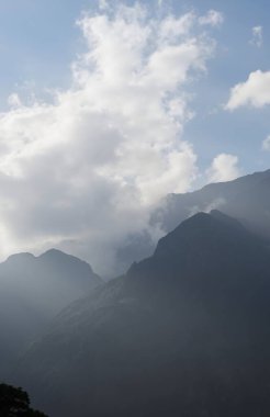 Bulutlu ve mavi gökyüzü olan dağ manzarası