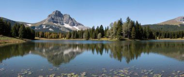 Güneşli bir günde göl ve dağların manzarası