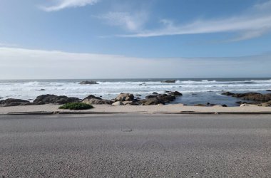 Kayalarla çevrili bir yolun dikey görüntüsü ve güzel bulutlu bir gökyüzü.