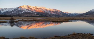 Yeni Zelanda 'nın dağlarında gölün üzerinde gün doğumu