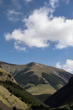 Bulutlu ve mavi gökyüzü olan dağ manzarası