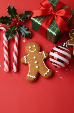 Zencefilli Noel kurabiyeleri, Noel ağacı dalları ve ahşap arka planda hediyeler.