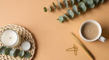 Tahta bir masada bir fincan kahve ve bir bitki.