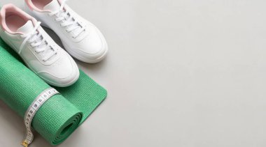 Yeşil arka planda beyaz spor ayakkabılar ve yeşil spor çantası